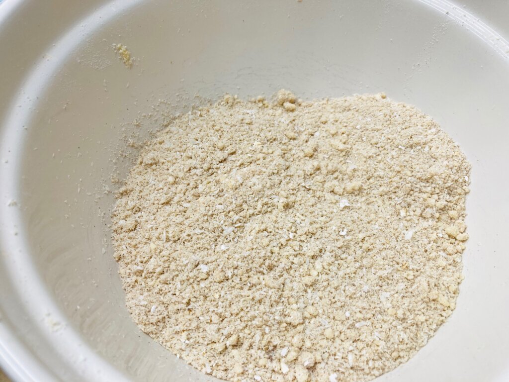 Crumble mixture in a large cream coloured mixing bowl.